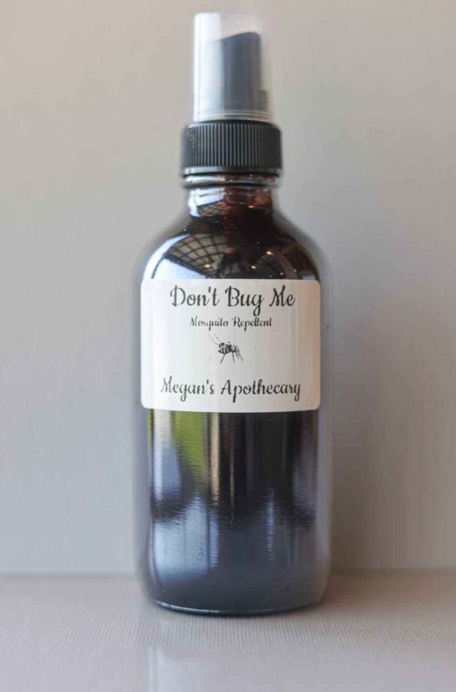 An amber spray bottle of Don&rsquo;t Bug Me mosquito repellent